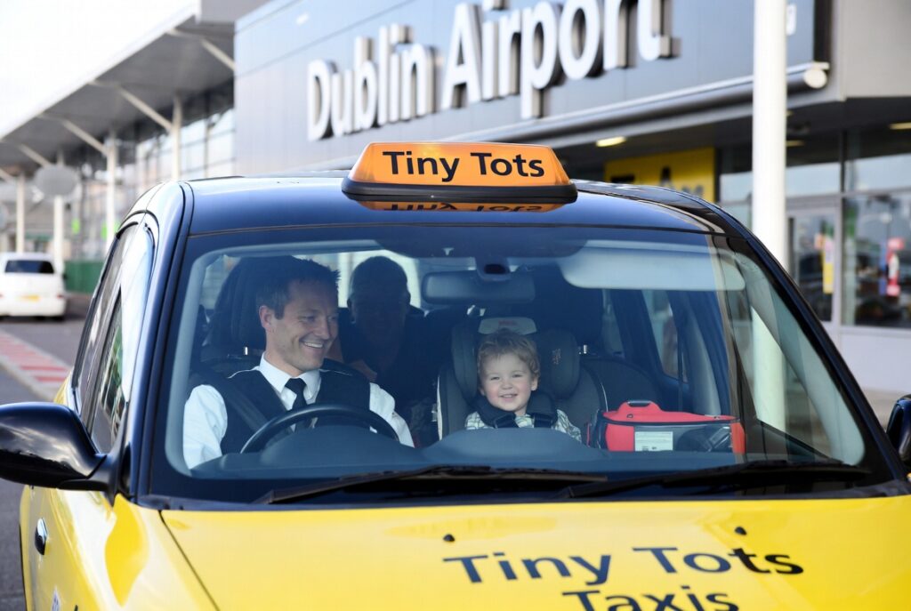 Family-friendly taxi in Dublin with toddler safely secured in car seat for airport transfer
